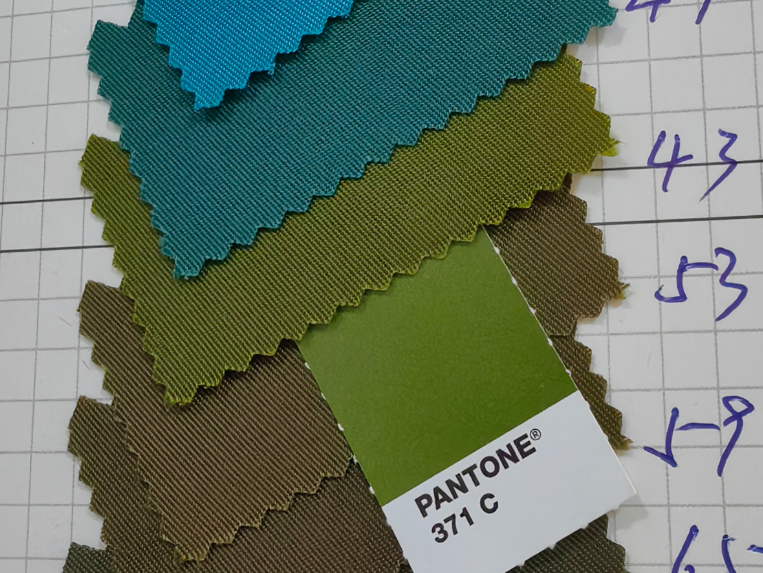 Dye to Match: fabric custom dyed to a client Pantone standard, shown against a Pantone 371 C chip